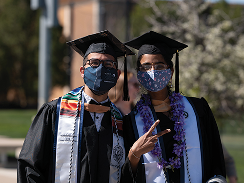 two graduates give thumbs up
